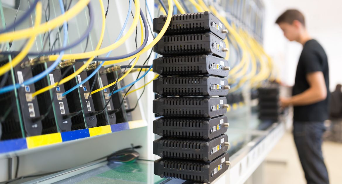 A man standing before a bank of test benches